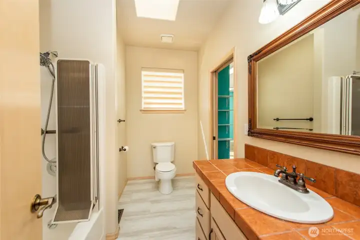 Guest bath attached to second bedroom and accessible from hallway.