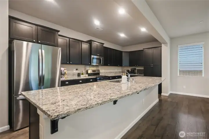 Fabulous slab granite island is DREAMY--tons of counter space, bar overhang, and lots of storage!