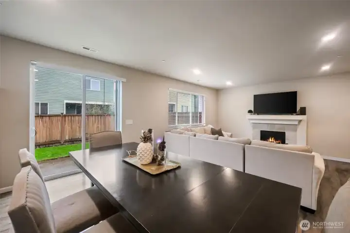 Great room view showing the slider to backyard and patio, and the stately fireplace positioned as the focal point on the far wall.
