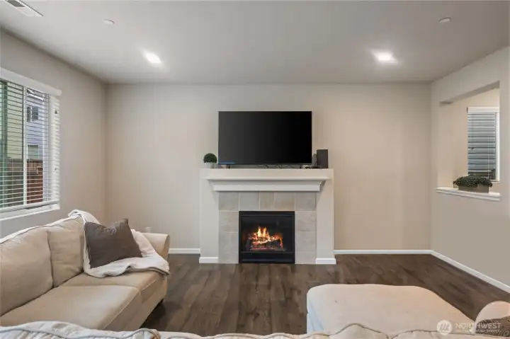 The dark, rich, easy-care laminate floors add warmth and contrast to the white trim and creamy walls. Office nook seen through opening on right.