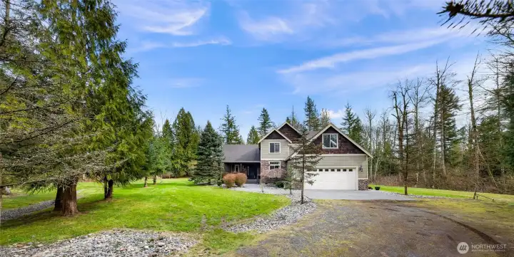 Welcome to 2259 H. St. Front exterior of home with expansive lawn, long driveway, and private setting