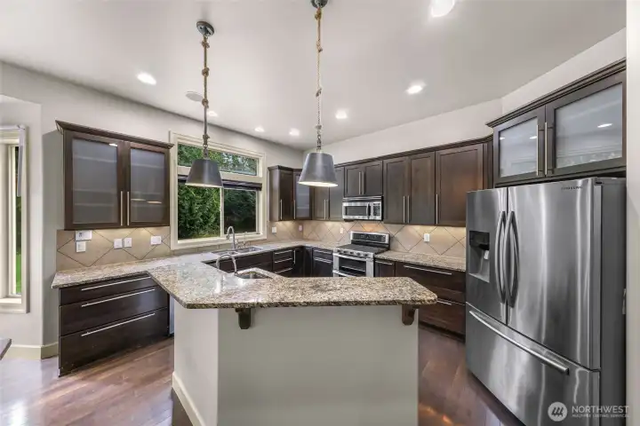 Kitchen with island seating, stainless appliances, and ample cabinetry