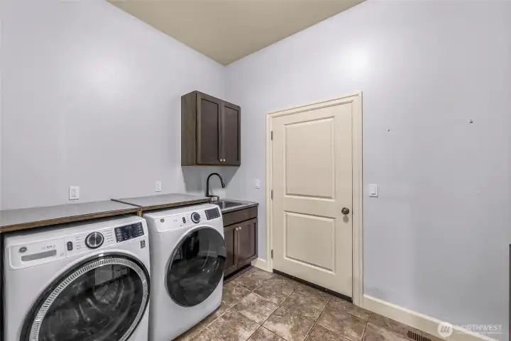 Laundry room with washer, dryer, and storage