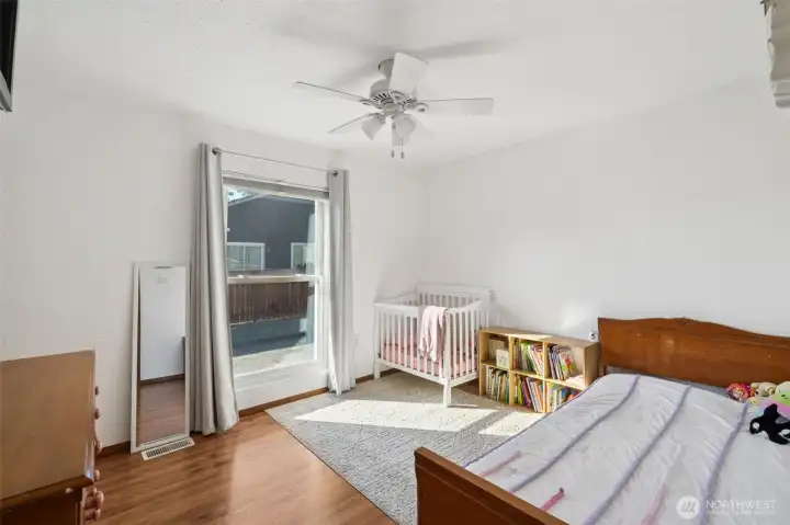 Large secondary bedroom with hardwood floors & ceiling fan.