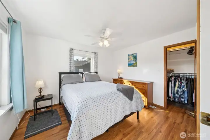 Main floor primary suite with hardwood floors, west facing front window allowing plenty of natural sunlight, ceiling fan & walk-in closet.