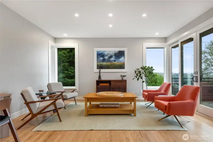 The family room/dining area is currently used as a gathering and gaming space, and flows to the adjacent deck through double sliding doors.