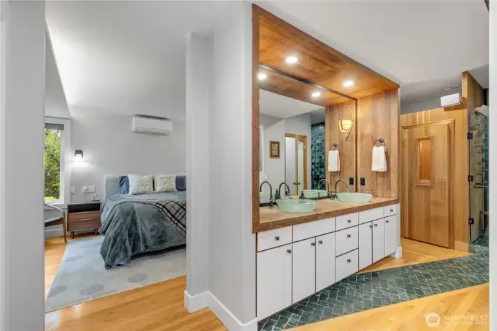 One level lower is the bedroom floor. The primary suite is an ideal retreat with a sauna, generously sized shower, and access to the hot tub spa just off the bonus room and on the deck at the garden's edge.