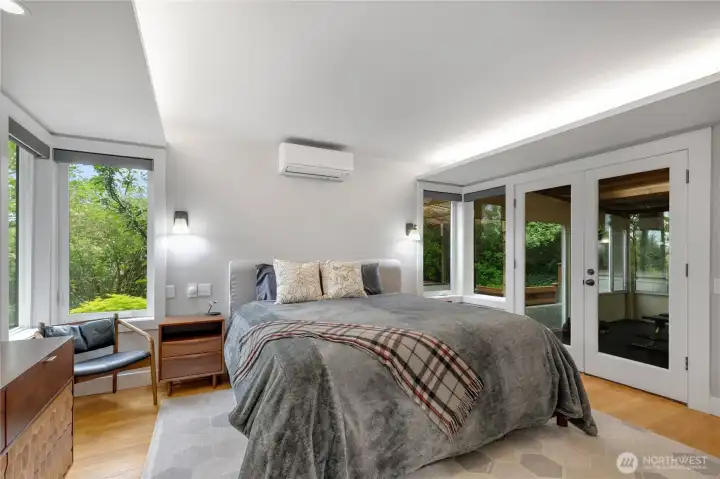 The window shades are app-controlled and provide comforting darkness when its time to sleep. The primary bedoom also has a separate mini split as well as being served by the whole-house HVAC system with central AC. The French doors lead to a bonus room currently being used as a workout space, and which flows to the deck and hot tub.