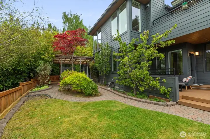 The garden space along the south side of the home is fully fenced and flows from the larger front deck , back to the covered hot tub deck, and around the small patio and deck off the rear bedroom.