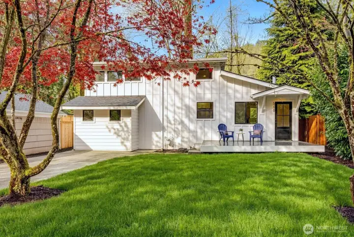 Stunning curb appeal with fresh board-and-batten siding, a welcoming front porch, and a manicured lawn.