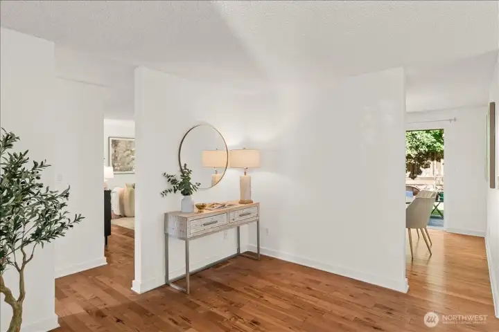 Welcoming interior hallway with hardwood flooring and space for decorative furnishings. Centrally located between the main living areas and casual dining room by the kitchen