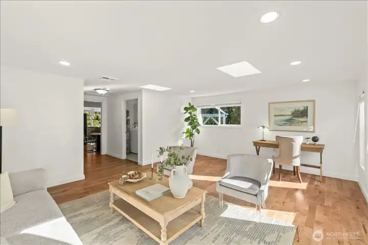 Living Room – Inviting living area with hardwood flooring, recessed lighting, and abundant natural light. Open floor plan provides versatile space for seating and gathering.