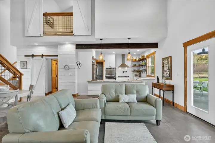 Soaring ceilings and open spaces create a sense of freedom, while the warmth of the fireplace draws family and friends together, becoming the backdrop for quiet mornings, lively conversations, and memories that linger long after the fire has faded.