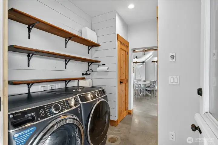 Utility Room w/ Washer/Dryer, half bath, split farm doors, and closet access to the radiant floor system.