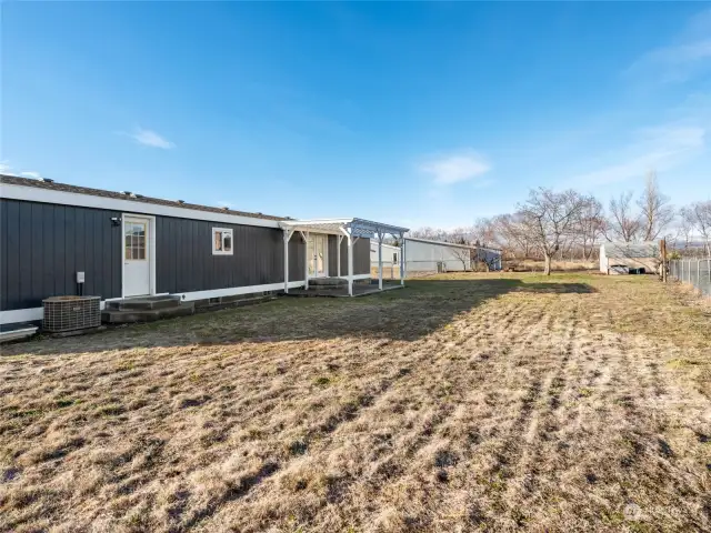 Large level backyard with small storage shed.