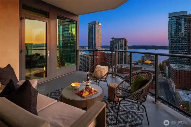 A large corner balcony extends from both the living room and the primary suite, offering a front-row seat to stunning sunsets over Elliott Bay and the Olympic Mountains.