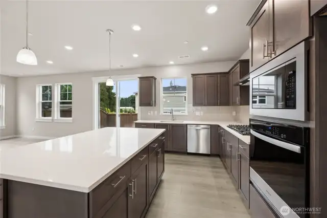 Gas cooktop, quartz countertops, gourmet hood vent, dishwasher, pendent lighting, soft close cabinets, built-in oven and microwave all included.