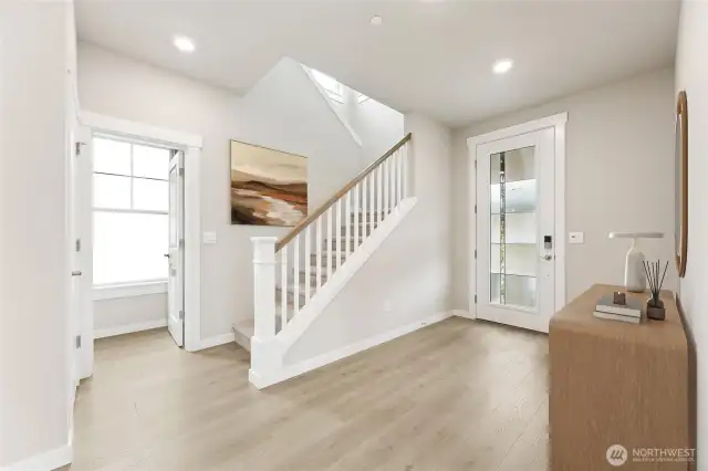 Large entry foyer with full glass front door and open railing.