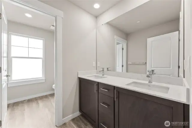 Double vanity and separate door to toilet and shower in hall bathroom.