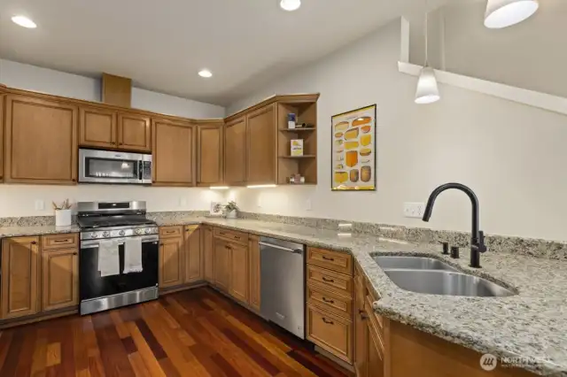 The kitchen features granite countertops a brand new refrigerator and gas stove range.