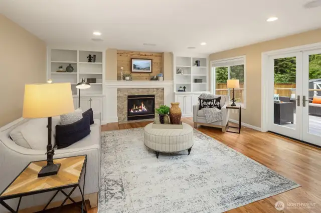 Stylish gas fireplace with calming surround, flanked by built-in cabinetry.