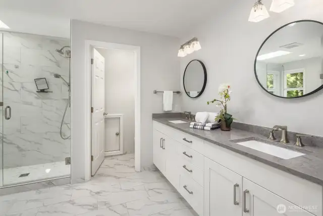 Spa-like Primary en-suite bathroom boasts walk in shower, soaking tub, private toilet, and walk in closet.