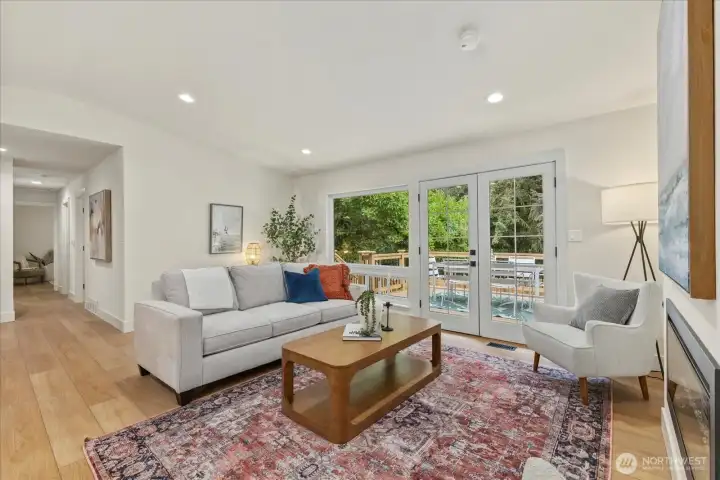 Spacious and bright living room with beautiful LVT flooring opens up to a brand new cedar deck.