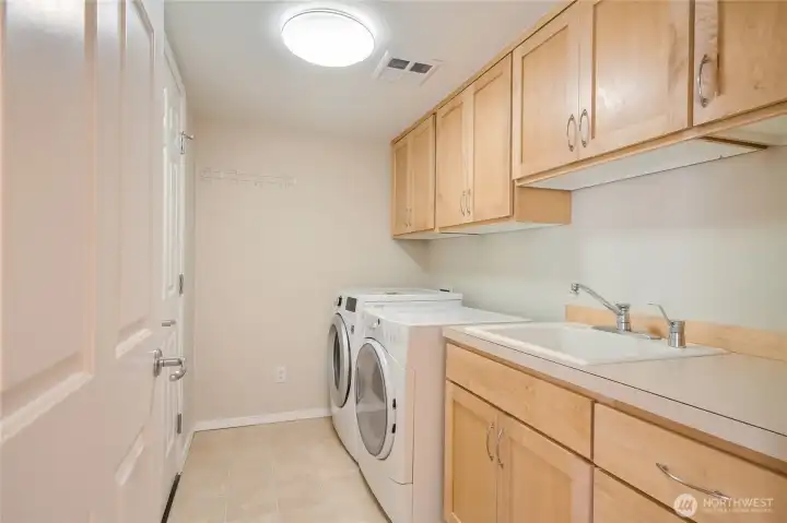 A true Utility and laundry room with laundry sink, cabinets, furnace, hot water, and yet more storage!