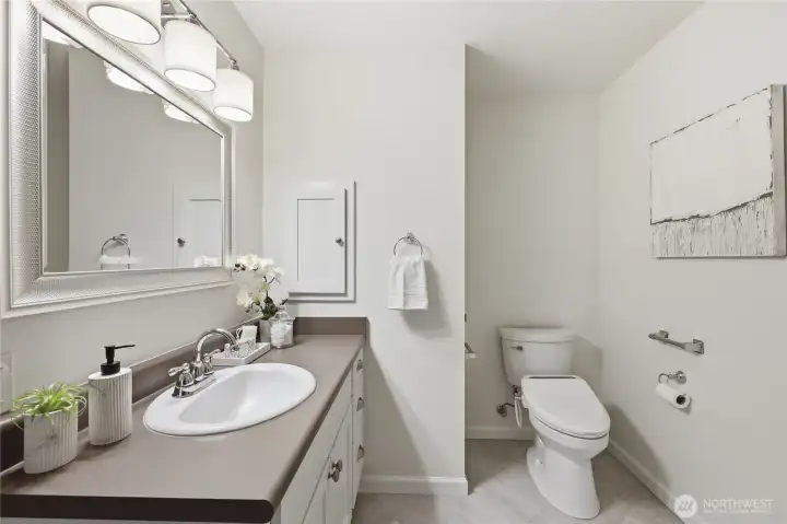 The bathroom has a bidet seat cover.