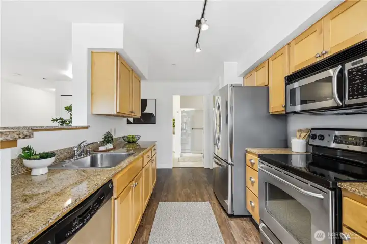 Quartz countertops and stainless appliances line the kitchen.