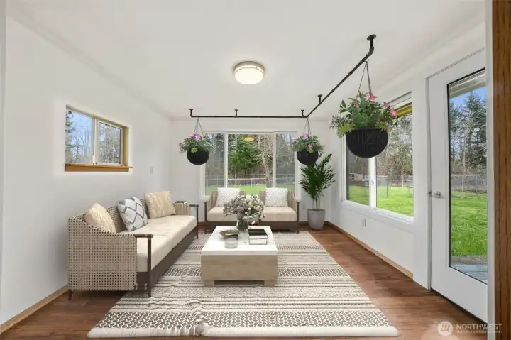 Sun room off living room with french door out to the deck that makes a great room for all your indoor plants. (Virtually staged)