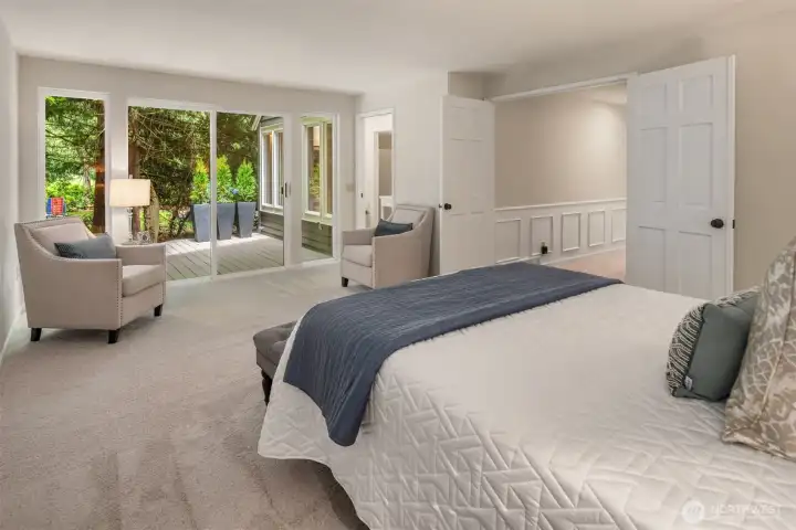 Privately situated down the hall, the expansive primary suite serves as a peaceful heaven. French doors open to a spacious bedroom with large windows and direct access to the wraparound deck that spans the back of the home. Privately situated down the hall, the expansive primary suite serves as a peaceful heaven. French doors open to a spacious bedroom with large windows and direct access to the wraparound deck that spans the back of the home.