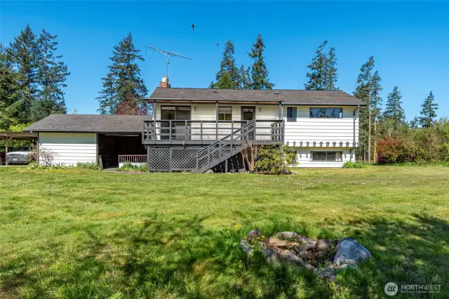 Looking at back of house with covered deck.