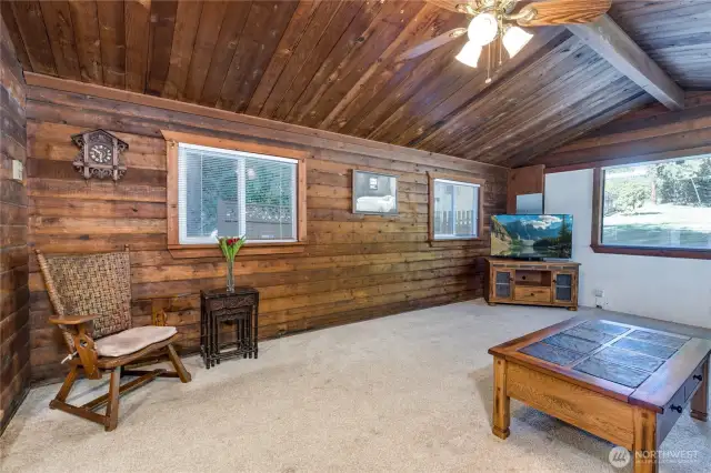 Living room has vaulted ceiling and a ceiling fan