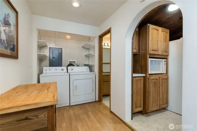 Central hall way has laundry nook with storage shelves. Washer & dryer stay.
