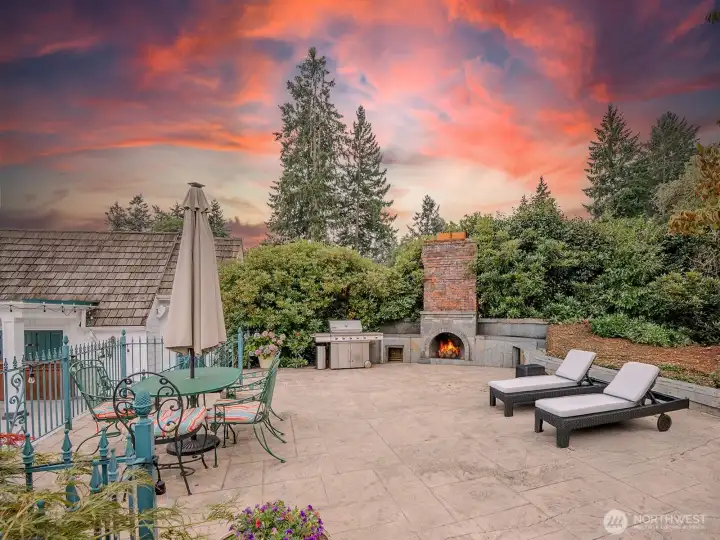 A large stone terrace between the main house and the boathouse. An outdoor fireplace makes this a great gathering place for family and friends