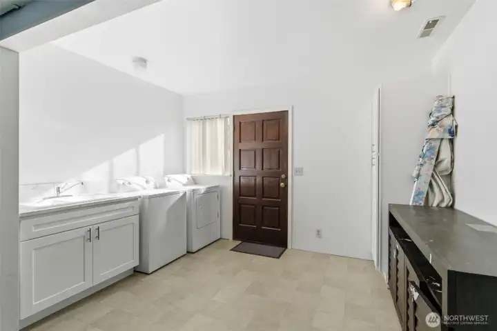 Large laundry area with sink and storage cabinets