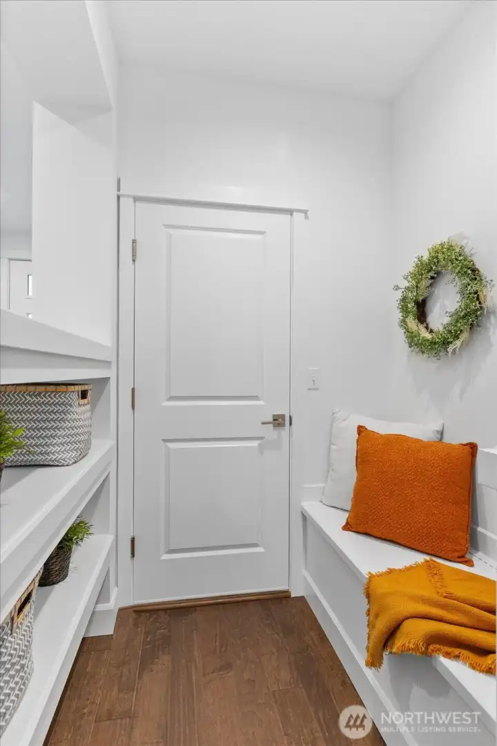 Great space leading to garage - storage/sit bench with storage shelves helps keep the home super organized!