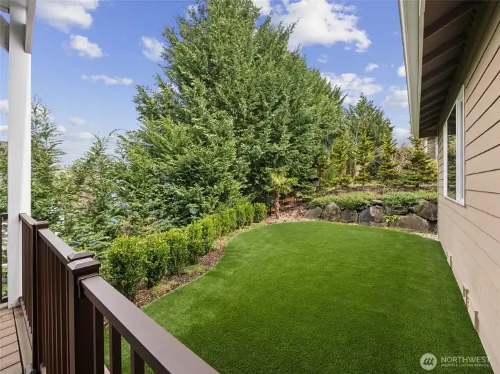 From the back deck looking into the easy maintenance artificial turf back yard.