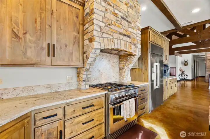 Chefs kitchen appointments. Propane range under the rock appointed stainless exhaust hood.