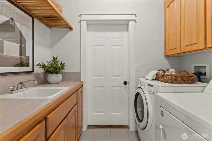 Laundry room features cabinetry, countertop workspace, utility sink, and additional storage. Laundry room features cabinetry, countertop workspace, utility sink, and additional storage.