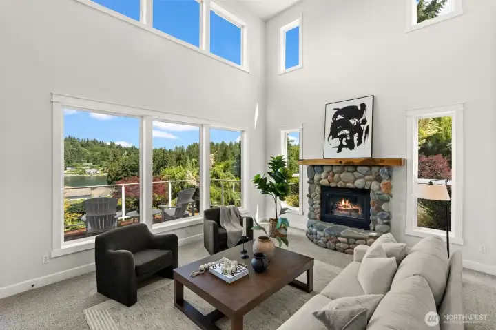 Light-filled great room offers a welcoming setting with a stone fireplace and views extending toward the water. Light-filled great room offers a welcoming setting with a stone fireplace and views extending toward the water.