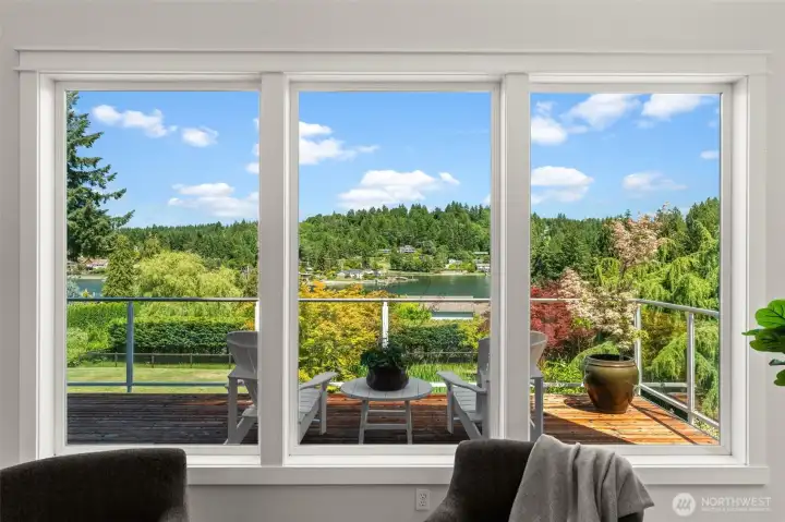 Large picture windows showcase views of the water, surrounding greenery, and outdoor living space. Large picture windows showcase views of the water, surrounding greenery, and outdoor living space.