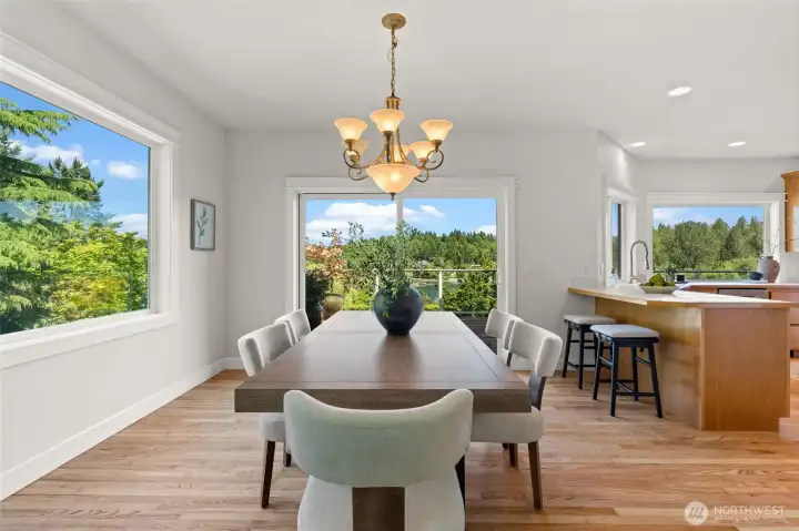Enjoy meals with a view in this welcoming dining area, thoughtfully positioned between the kitchen and deck to take advantage of the water and landscape views. Enjoy meals with a view in this welcoming dining area, thoughtfully positioned between the kitchen and deck to take advantage of the water and landscape views.