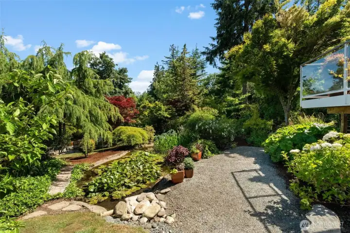 Meticulously maintained gardens include a pond, ornamental plantings, and lush natural surroundings. Meticulously maintained gardens include a pond, ornamental plantings, and lush natural surroundings.