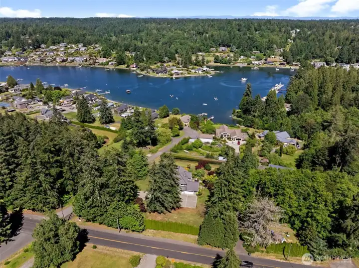 Aerial image highlights the property's spacious setting surrounded by mature trees and water views. Aerial image highlights the property's spacious setting surrounded by mature trees and water views.