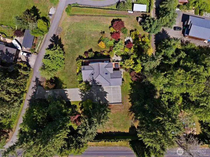 Bird's-eye view captures the home's position on a large lot surrounded by established trees and landscaping. Bird's-eye view captures the home's position on a large lot surrounded by established trees and landscaping.