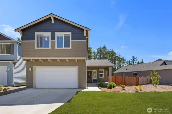 Front exterior featuring a covered entry, attached garage, and established landscaping.