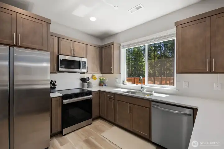 Additional kitchen view showcasing the functional layout, generous workspace, and window overlooking the backyard.