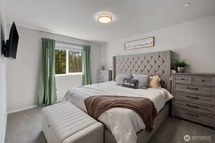 Bedroom with large windows, natural light, and carpet flooring.